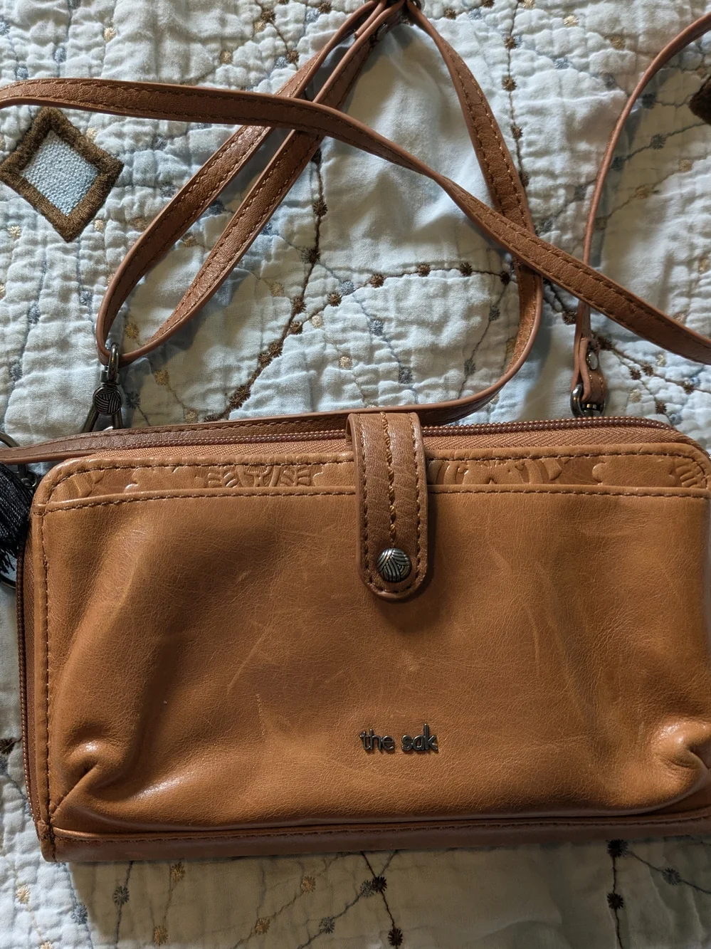 The Sak tan leatherette crossbody wristlet